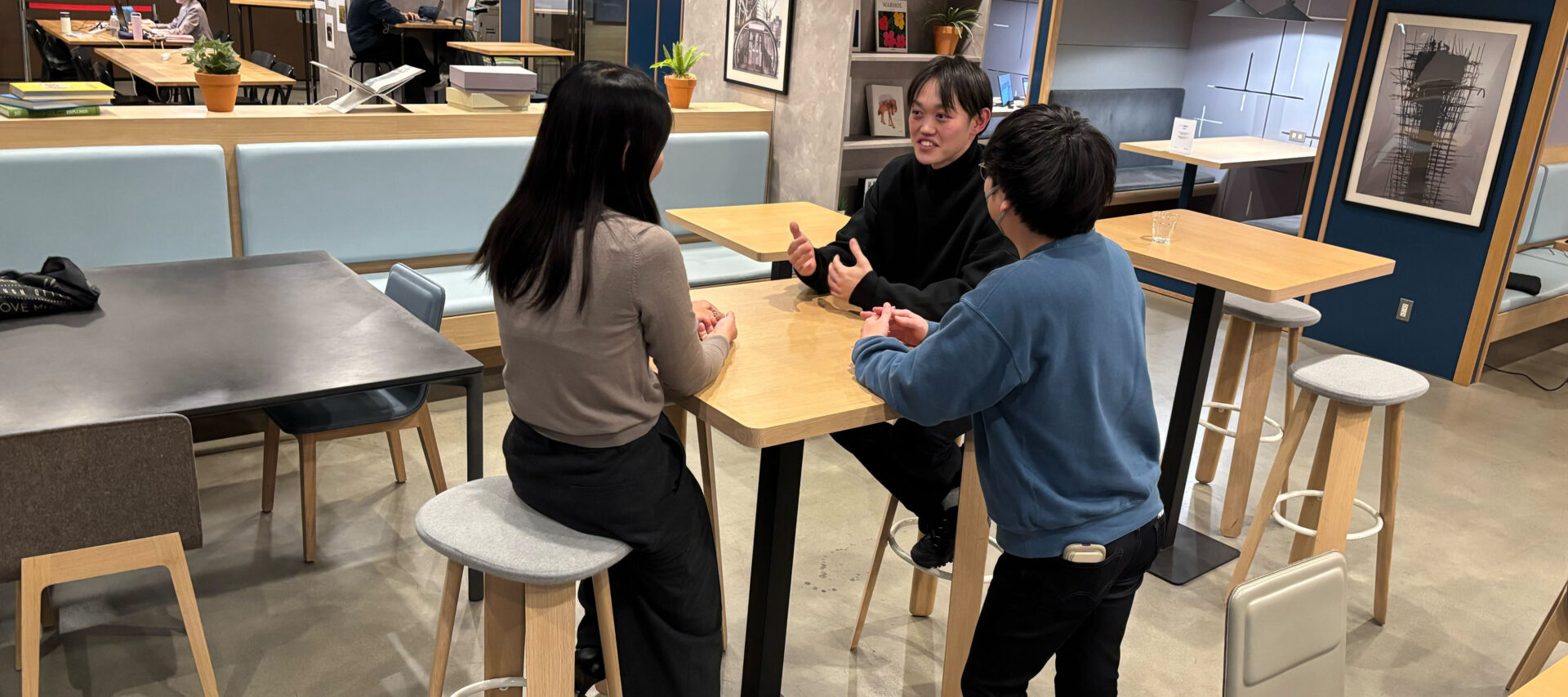 3名がオフィスのテーブルを囲んでざっくばらんに語り合う様子